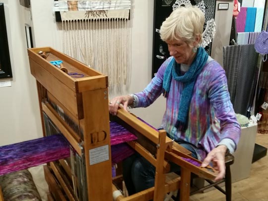 Barbara Decker demonstrating her prowess on a loom at Cazenovia Artisans