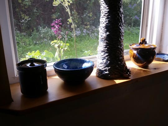 Ceramic pieces by Shawn McGuire glowing in a sunny window